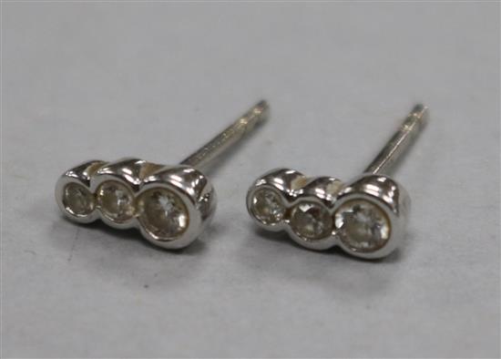 A pair of 18ct white gold and collet set graduated three stone diamond earstuds, approx. 7mm.